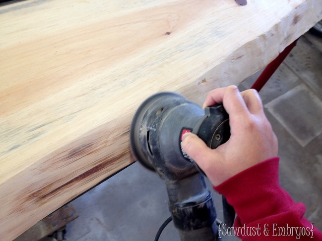 Sanding live edge wood after removing bark.